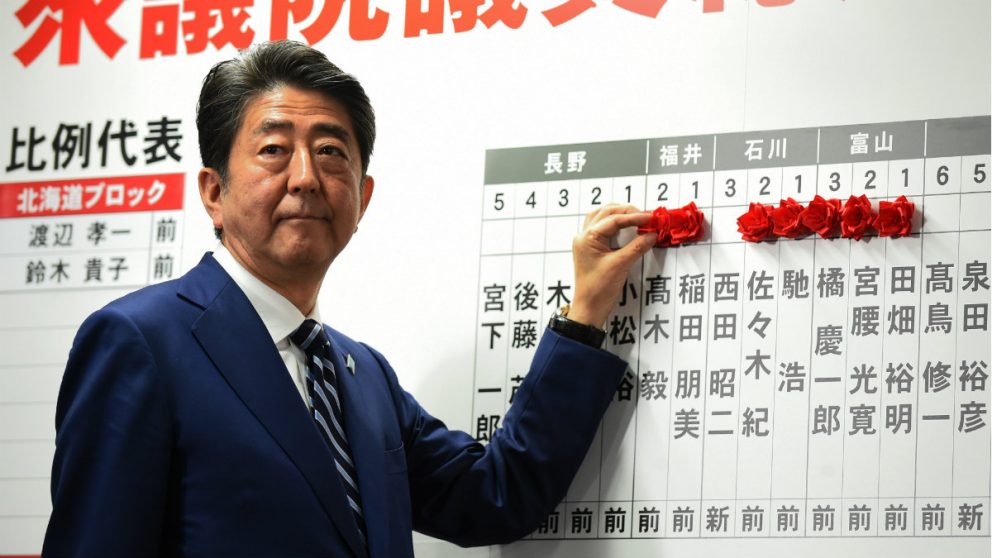 El primer ministro japonés, Shinzo Abe, marca con rosas los nombres de sus diputados electos en los comicios legislativos. (AFP)