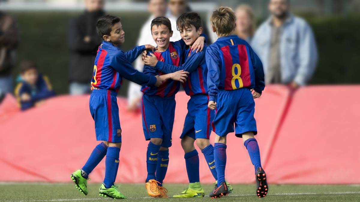 Algunos niños de la Escola del FC Barcelona celebran un gol.