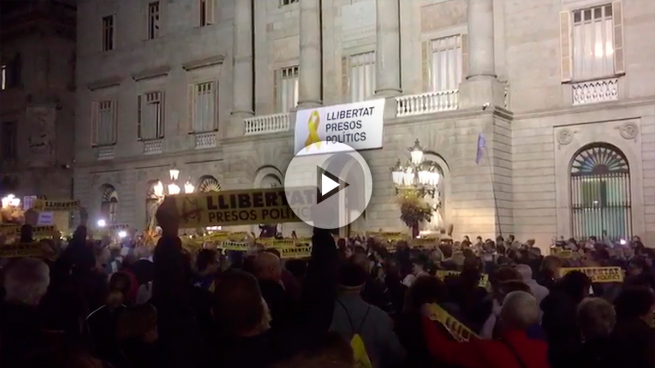 Independentistas protestan en Sant Jaume entre las dos banderas de España que presiden los edificios