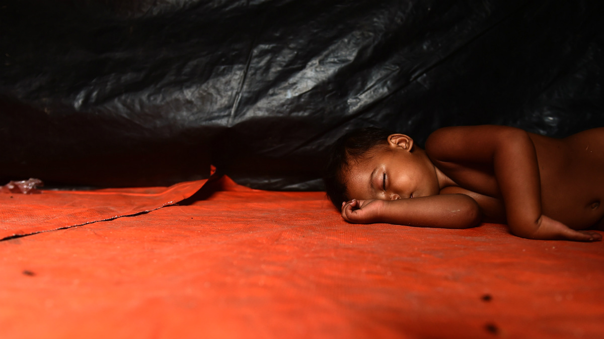 Un bebe rohingya duerme en una tienda del campo de refugiados de Thankhali, en Bangladesh. (AFP)