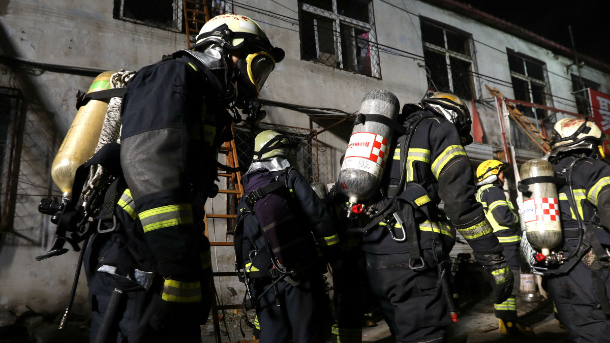 Bomberos ante la vivienda incendiada (Foto: AFP).