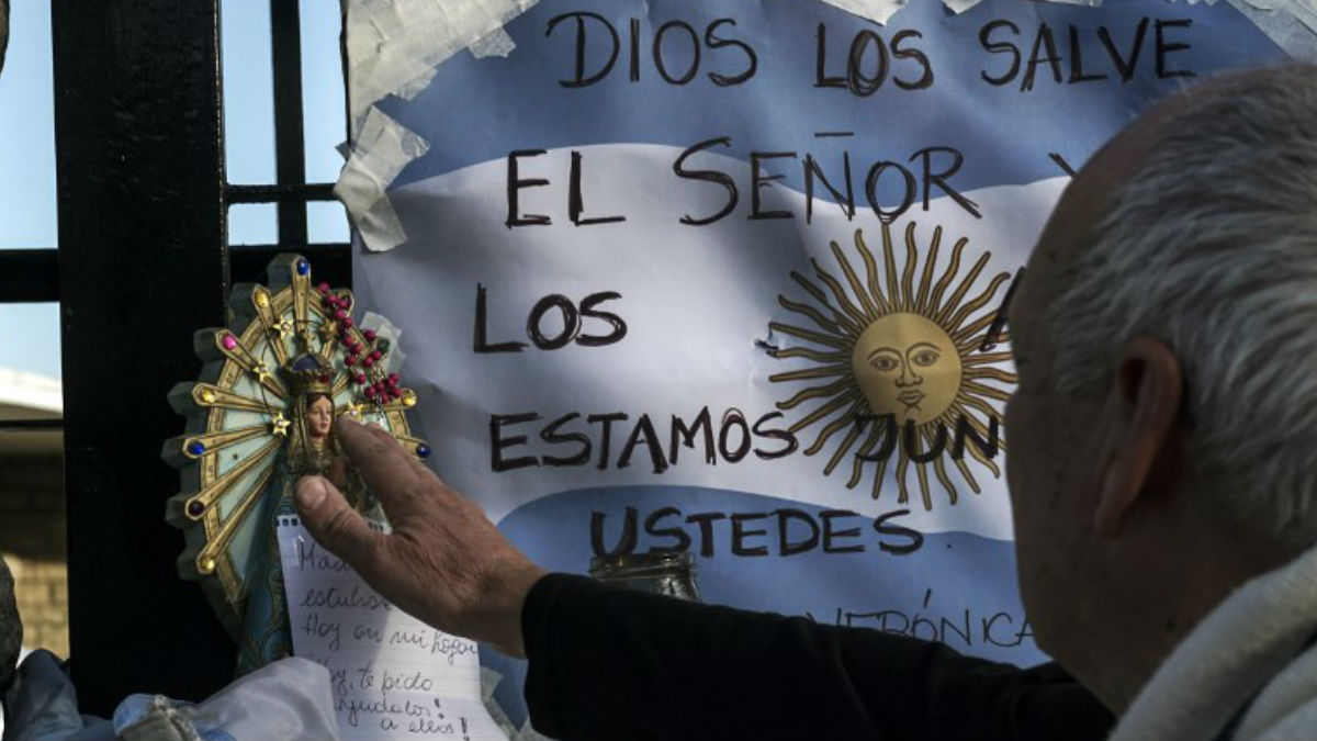 Mensajes de apoyo a los 44 tripulantes del submarino argentino desaparecido y a sus familiares frente a una Virgen de Luján, patrona de Argentina. Foto: AFP
