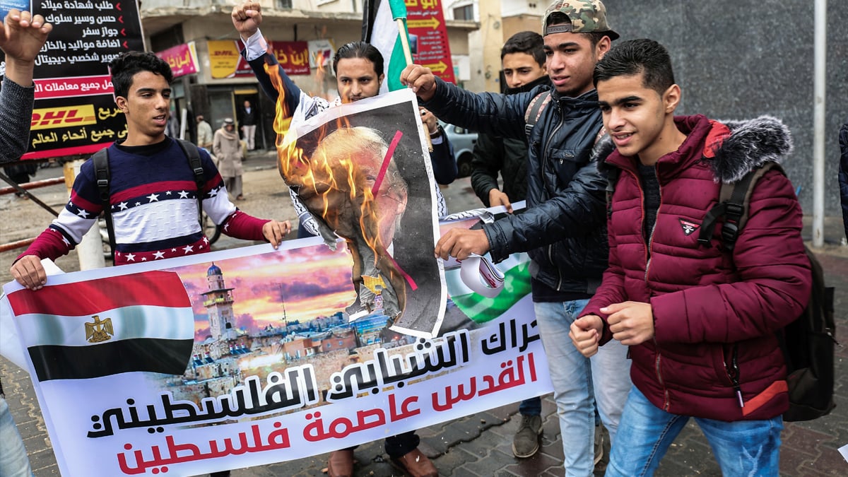 Jóvenes palestinos queman una fotografía de Donald Trump en Rafah. (Foto: AFP)