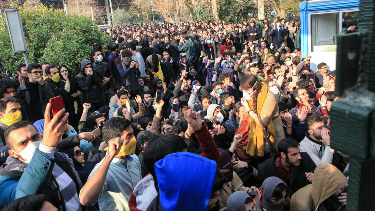 Manifestantes graban con sus móviles las marchas contra el Gobierno en Irán ante la Universidad de Teherán. (AFP)
