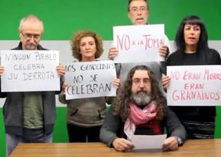 Separatistas andaluces con carteles contra la fiesta de la Toma de Granada en los que se puede leer "Los genocidios no se celebran" 