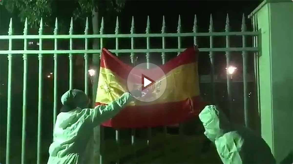 Dos cachorros de la CUP con la cara tapada quemando una bandera de España.