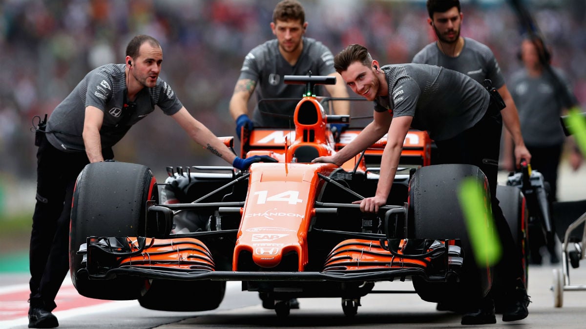 Los mecánicos de McLaren retiran el monoplaza de Alonso en Brasil. (Getty)