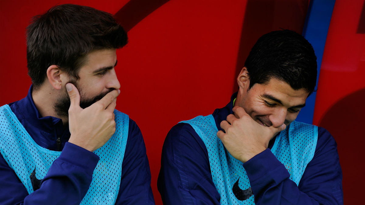 Gerard Piqué y Luis Suárez hablan en el banquillo (Getty)
