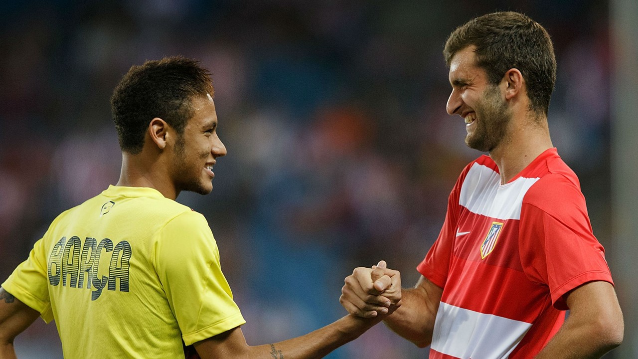 Neymar se saluda cariñosamente con Leo Baptistao en un partido.