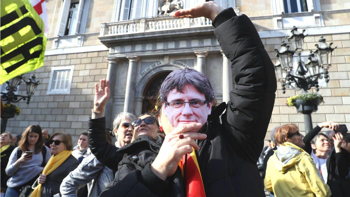 Una mujer con una careta de Carles Puigdemont ante el Palau de la Generalitat.