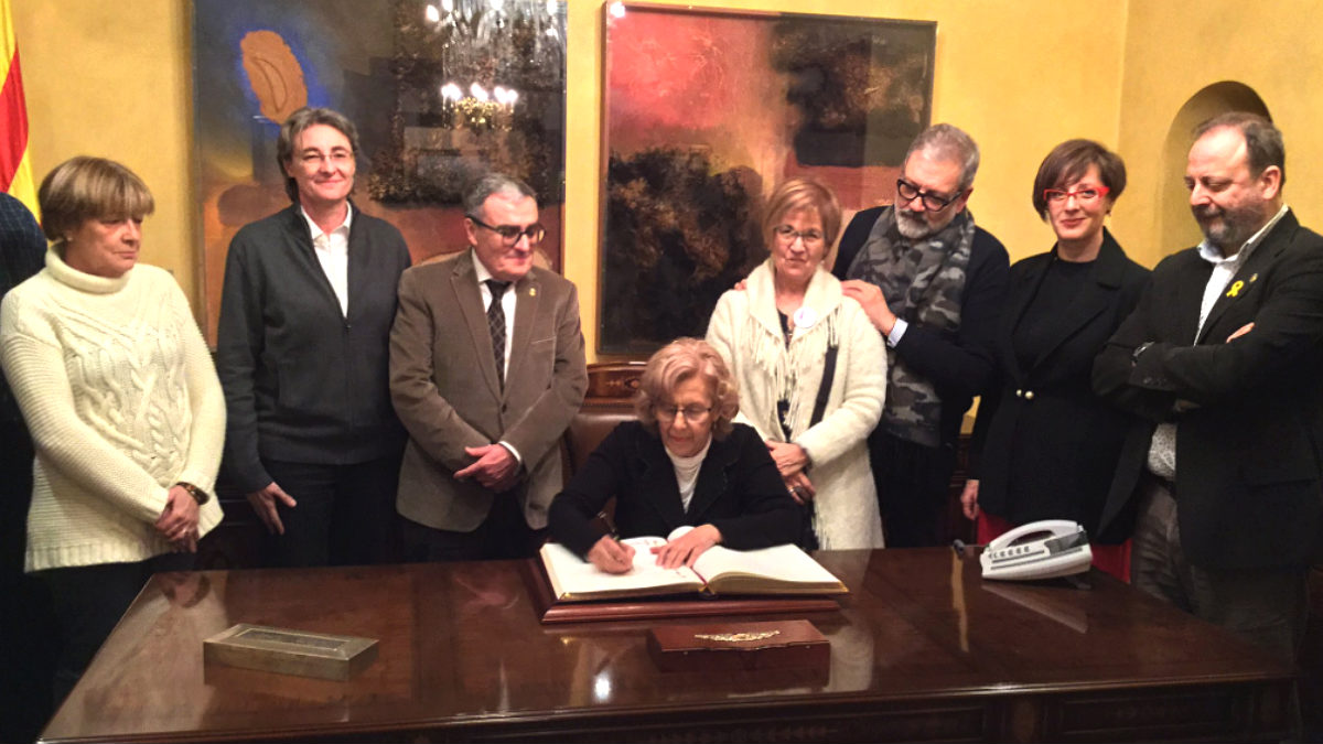 Carmena, firmando en el libro de honor del Ayuntamiento de Lérida.