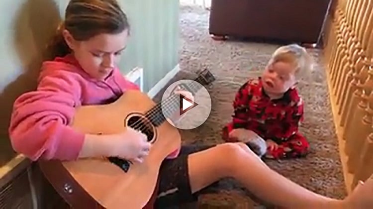 Niña cuidando de su hermano con síndrome de Down