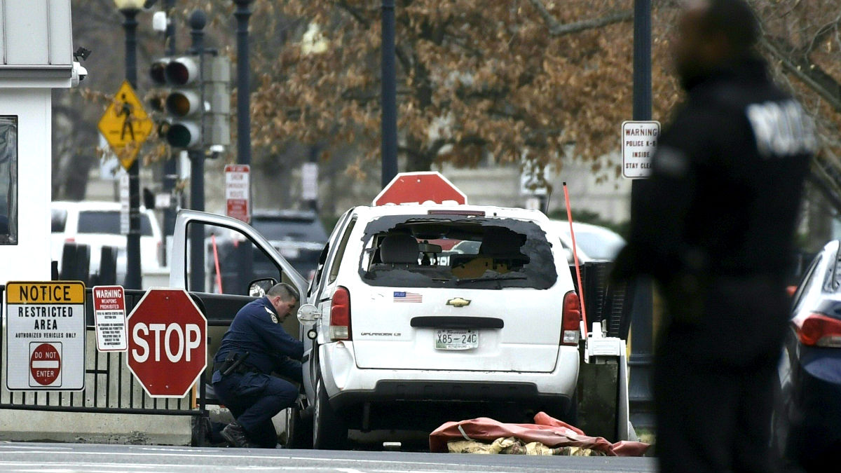 Un agente inspecciona el vehículo que se estrelló contra una valla de seguridad de la Casa Blanca (Foto: AFP).