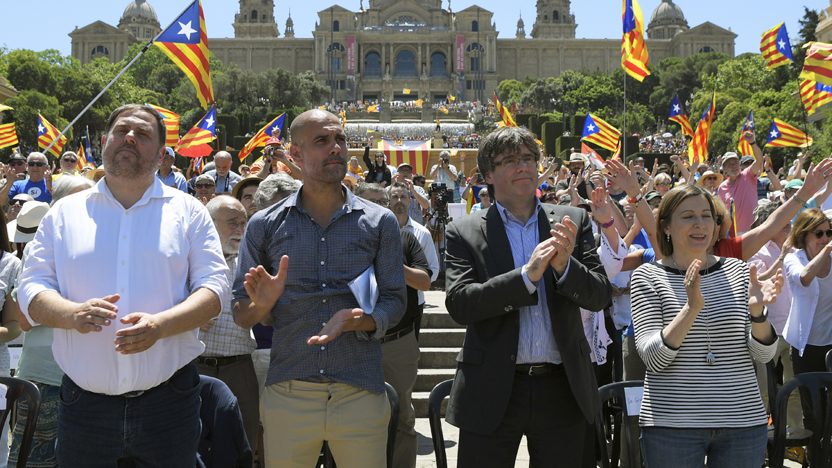 Pep Guardiola con los líderes golpistas en un acto en Barcelona. (Foto: AFP)