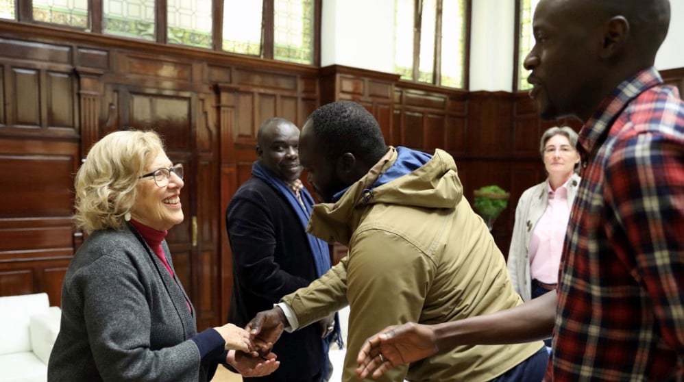 Manuela Carmena saludando a los inmigrantes senegaleses. (Foto. Madrid)