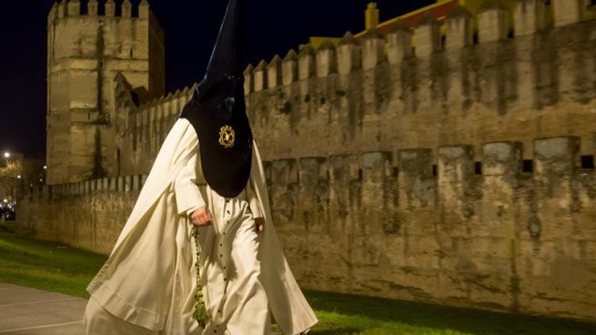 Un nazareno de la Hermandad de La Macarena se dirige al Templo para efectuar su estación de Penitencia en la Madrugá, la noche grande de la Semana Santa de Sevilla.