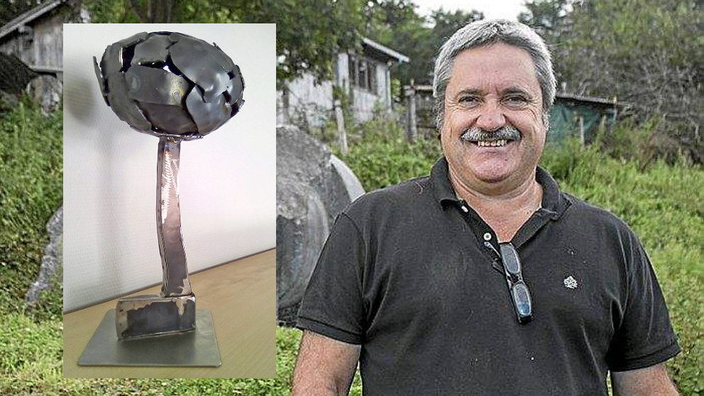 El escultor guipuzcoano Koldobika Jauregi y su obra ‘Arbolaren Egia’ con el hacha de ETA invertida.