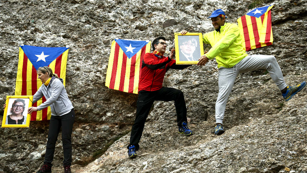 Independentistas subiendo las fotos de los presos golpistas a Montserrat (Foto: AFP).