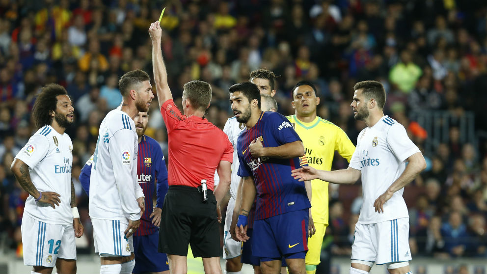 Hernández Hernández muestra la cartulina amarilla a Sergio Ramos durante el Clásico Barcelona – Real Madrid. (AFP)
