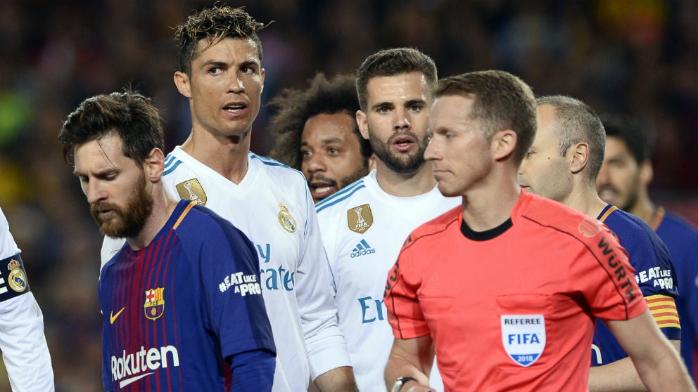 Messi, junto a Hernández Hernández en el Barcelona-Real Madrid del Camp Nou. (AFP)