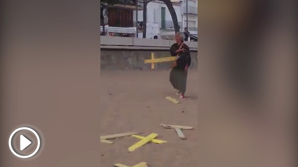 Una españolista retira cruces amarillas en la playa de Llafranc (Gerona) ante amenazas de los separatistas