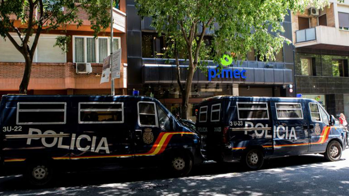Furgones de la policía la custodian la sede de la patronal de la pequeña y mediana empresa de Cataluña (PIMEC), durante los registros efectuados esta mañana por la UDEF en una macrooperación contra la Diputación de Barcelona por un presunto fraude de subvenciones (EFE).