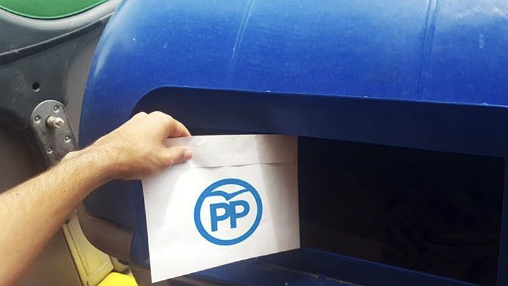 Las juventudes del PDeCAT tiran sobres del PP al contenedor azul.