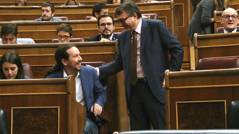 El portavoz del PNV, Aitor Esteban (d), saluda al líder de Unidos Podemos, Pablo Iglesias (2i), al inicio de la primera jornada de la moción de censura presentada por el PSOE contra el presidente del Gobierno, Mariano Rajoy, hoy en el Congreso. (Foto: Efe)