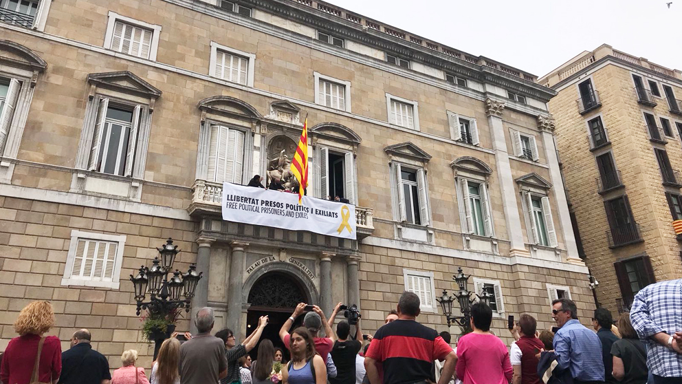 Una gran pancarta por los «presos políticos y exiliados» preside el Palacio de la Generalitat. (Foto: Joan Guirado/OKDIARIO)