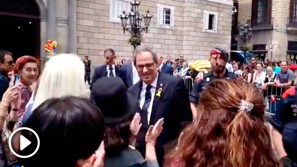 Quim Torra sale a saludar a la gente congregada frente a la Generalitat y les señala la pancarta donde pide «libertad para presos políticos y exiliados». Foto: Twitter