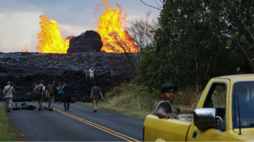 Un grupo de periodista frente a un río de lava provocado por la erupción del Kilauea en Hawai. Foto: AFP