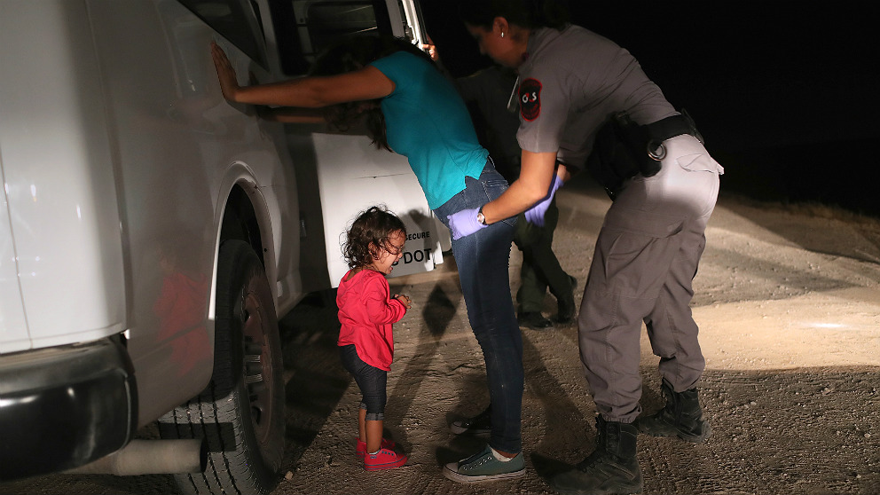 Una niña hondureña llora desconsolada mientras una agente de Nuevo México cachea a su madre. (Foto: Getty)