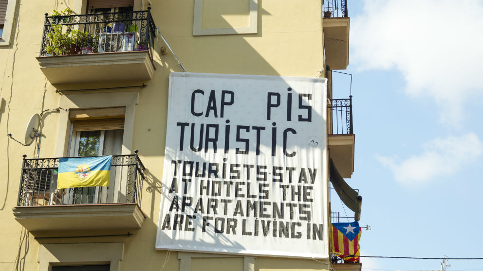 Tablero colgado de un balcón hecho por vecinos de la campana de la Barceloneta en Barcelona, quejándose de apartamentos y overpopulating de turismo en Barcelona (Foto: iStock)