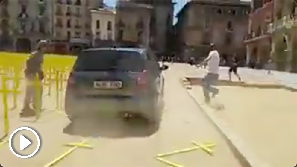 Un coche arolla las cruces amarillas en la plaza de Vic.