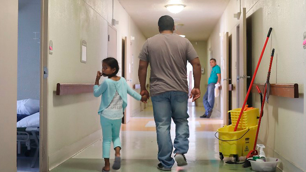 Un padre inmigrante con su hija, reunidos el pasado mes de julio, tras ser separados y posteriormente detenidos por la política «tolerancia cero» de Donald Trump. Foto: AFP