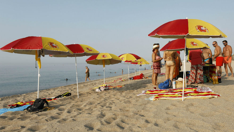 Sombrillas y toallas con los colores de España en una playa de Arenys de Mar (Barcelona). Foto: EFE