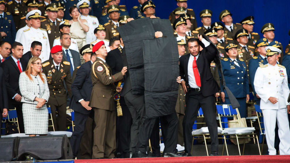 Momento en el que los escoltas de Maduro despliegan un escudo antibalas para protegerle.