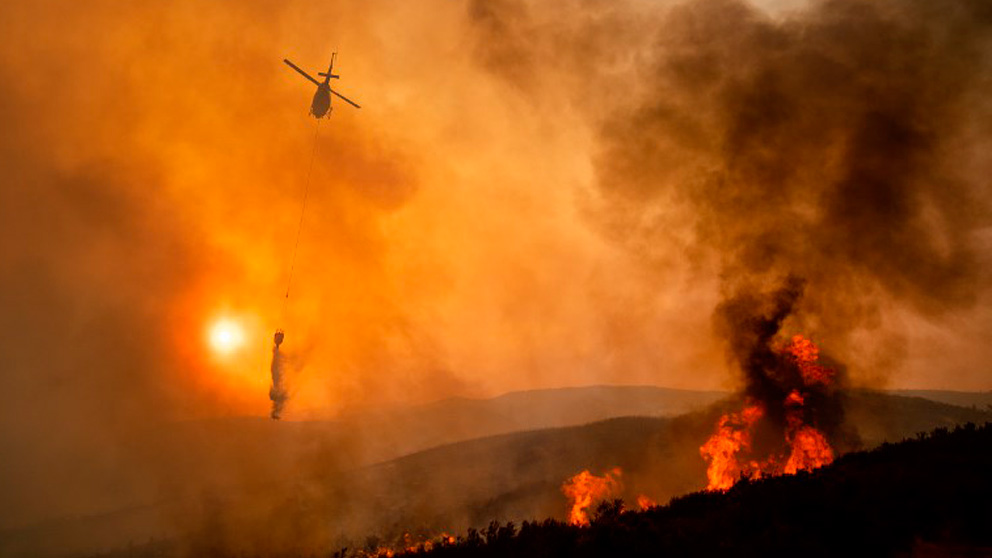 Un helicóptero trabaja en las labores de extinción del incendio declarado en Mendocino, California. Foto: AFP
