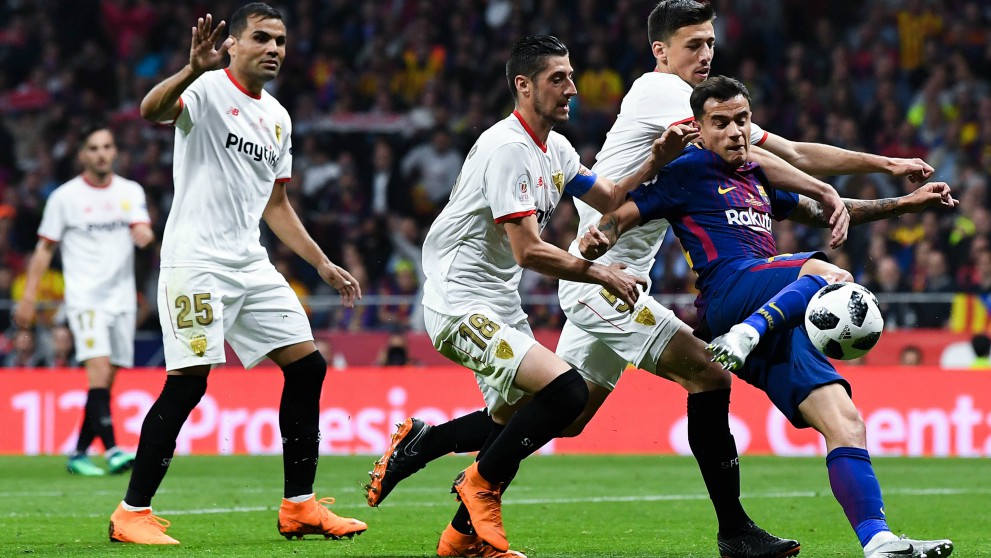 Coutinho pelea por un balón con jugadores del Sevilla. (Getty)