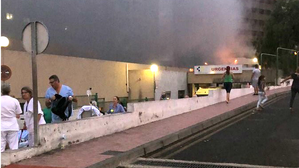 Las llamas asoman junto a la entrada de Urgencias del Hospital de La Candelaria en Tenerife. (EP)