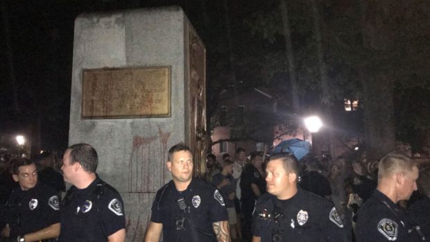 Policías custodian el pedestal ya vacío donde estaba la estatua en memoria de los soldados confederados de la Universidad de Carolina del Norte. Foto: Twitter
