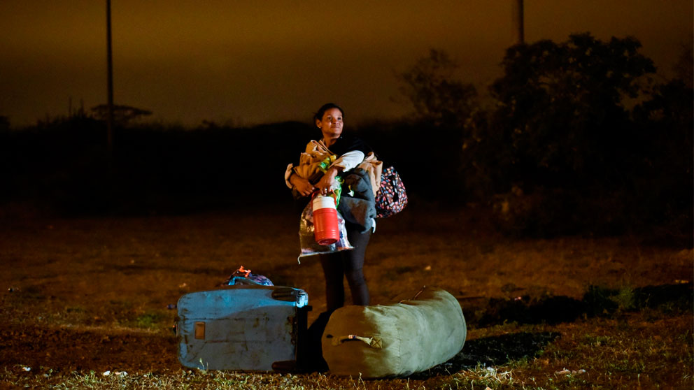 Una mujer venezolana con su hijo en brazos tras cruzar la frontera de Venezuela con Perú.  Foto: AFP