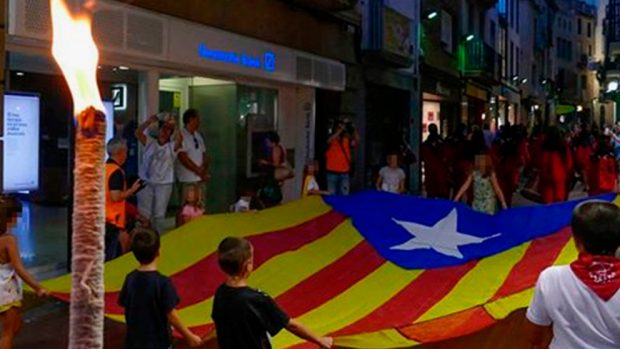 Un grupo de niños abriendo la marcha de antorchas de Tarrasa portando una gran bandera independentista