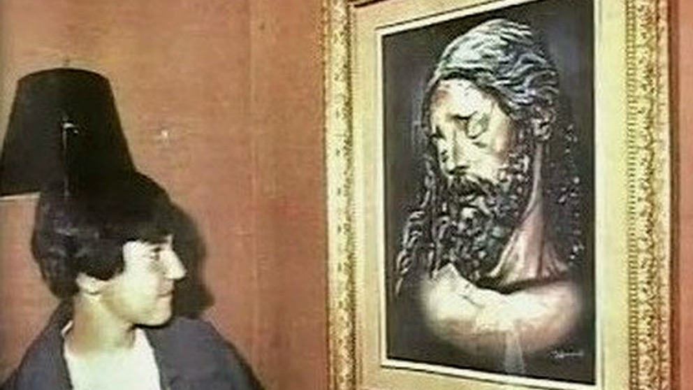 David Guerrero, el desaparecido en 1987 conocido como el Niño pintor de Málaga, junto al Cristo de la Buena Muerte pintado por él.