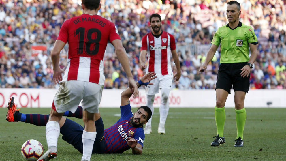 Luis Suárez cae al suelo delante de Jaime Latre. (AFP)