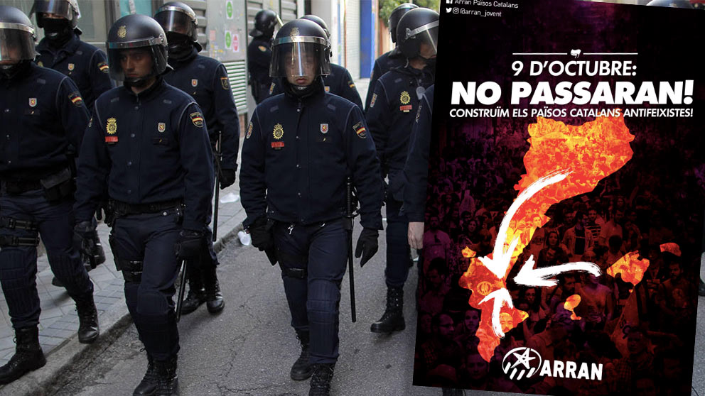 Una unidad de policías antidisturbios y el cartel de una manifestación separatista en Valencia.