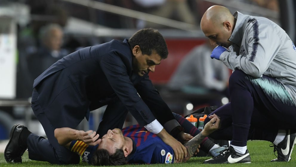 Messi es atendido por los médicos tras lesionarse el codo. (AFP)