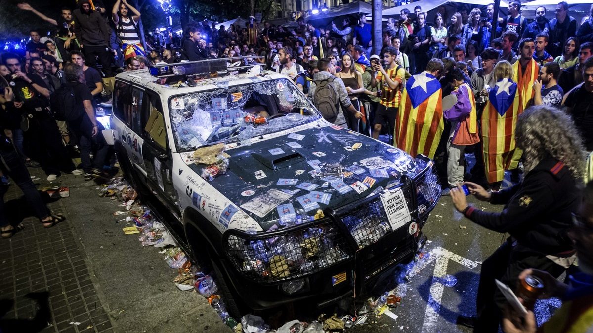 Imagen del asedio a la Conselleria de Economia y del coche de la Guardia Civil atacado