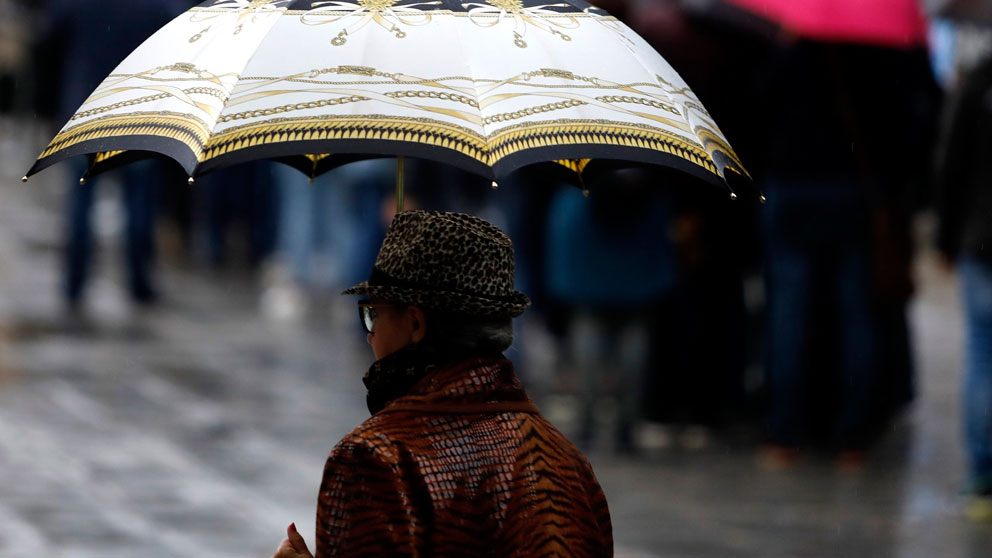 Una mujer se resguarda de la lluvia con un paraguas. Foto: Europa Press