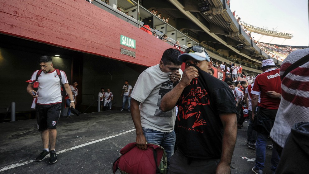 Aficionados se tapan tras los incidentes en el Monumental. (AFP)